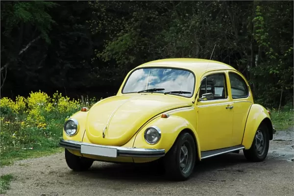 yellow old VW Beetle 1302 on sandy ground