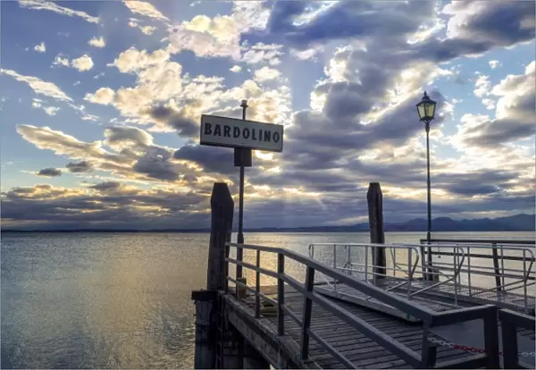 Sunset over pier at lake Garda in Bardolino Italy. Panoramic view on sunset over pier