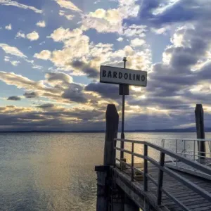 Sunset over pier at lake Garda in Bardolino Italy. Panoramic view on sunset over pier Sunset over pier at lake Garda in Bardolino Italy. Panoramic view on sunset over pier