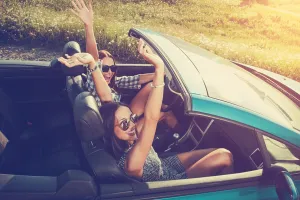 Two attractive young women in a convertible car